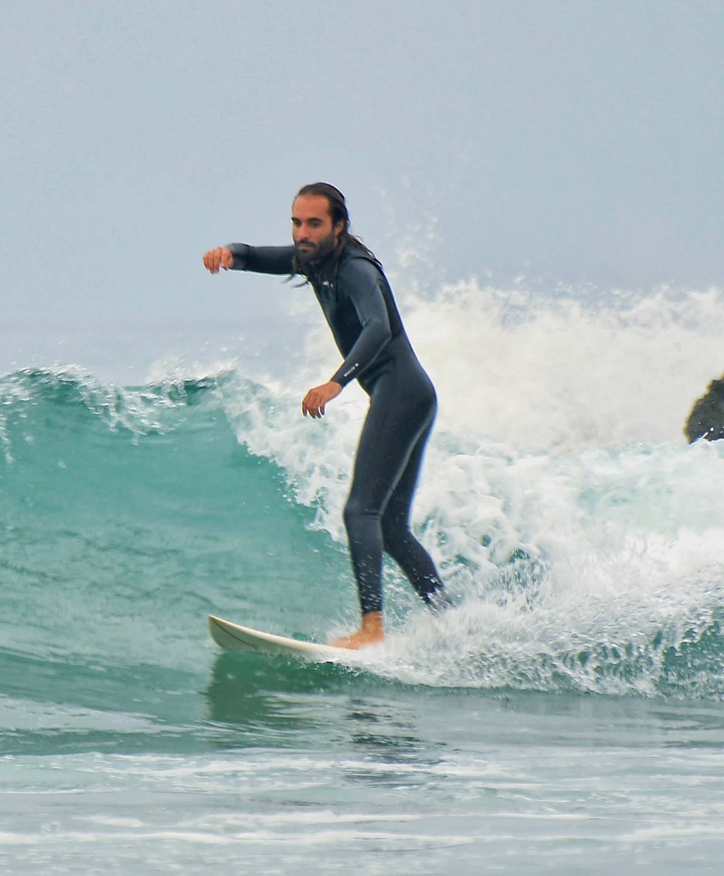 Mounaime, founder and surf instructor at Playtide Surf School in Tamraght, riding a wave