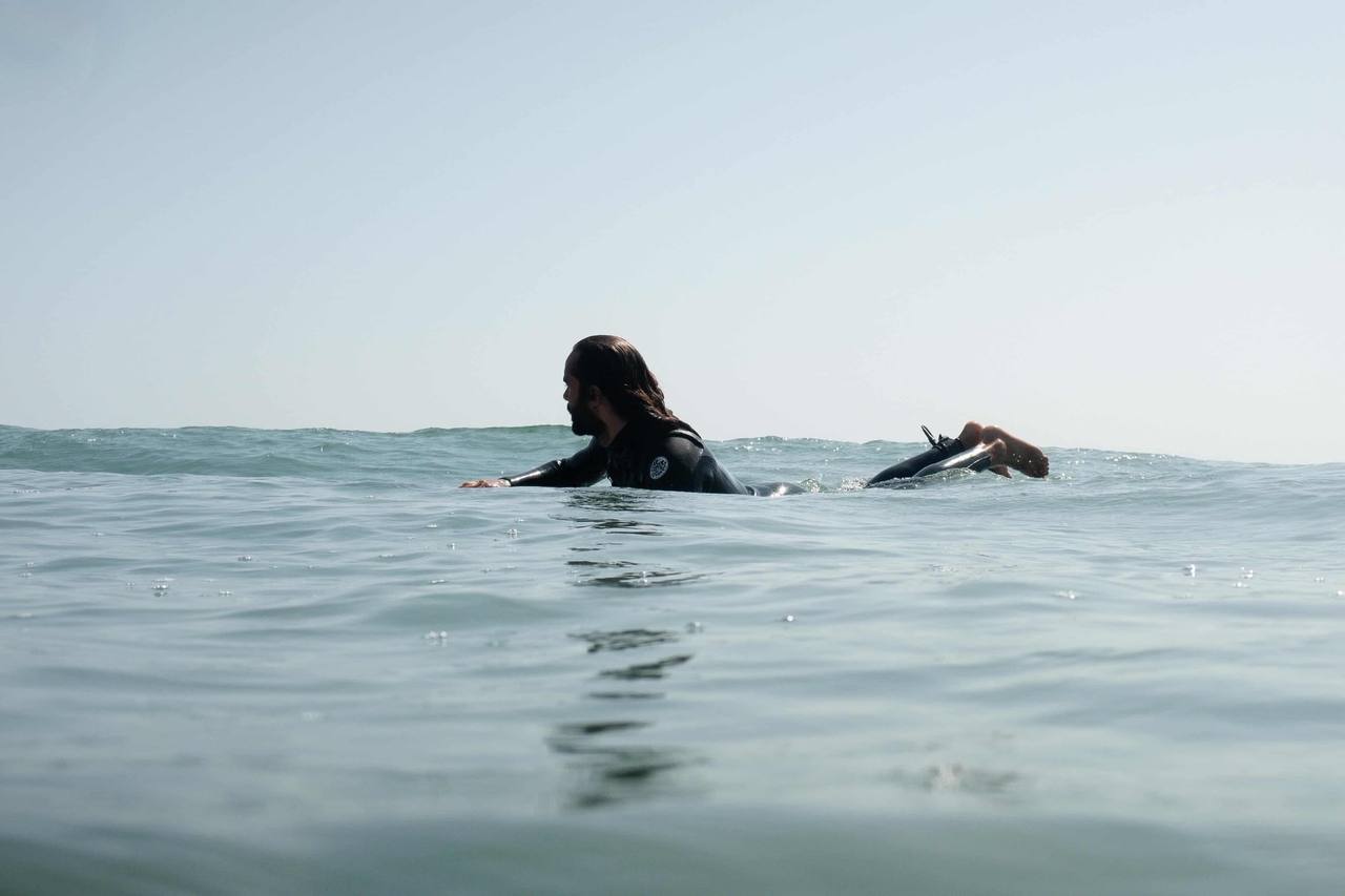 Surfer lying on his board in the water, paddling out